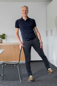 a man standing next to a chair in an office