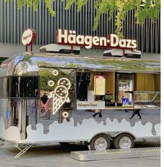 an ice cream truck parked in front of a building with the word haagen - daas on it