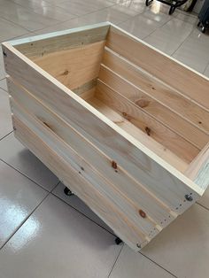 a wooden box sitting on top of a tile floor