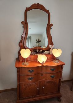 an antique dresser with three lamps on top