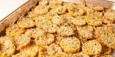 a pan filled with cooked food sitting on top of a white tablecloth covered counter