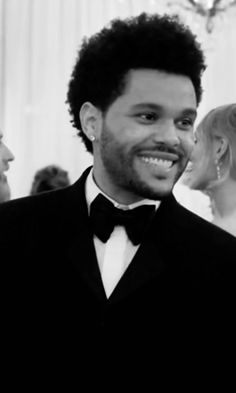 a man in a tuxedo smiles at the camera