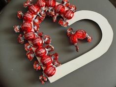 a heart made out of candy canes on top of a black surface with the word comparir