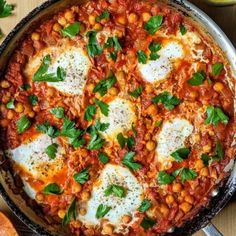 baked beans and eggs in a skillet with parsley on the side next to bread