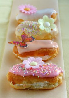 three donuts with frosting and sprinkles are lined up in a row