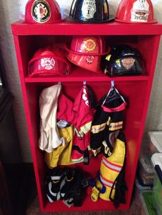 the fireman's gear is neatly organized on this red shelf