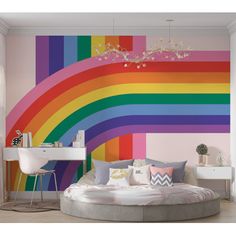 a room with a rainbow wallpaper and a round bed in front of a desk