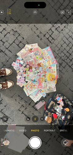 a person standing next to an umbrella covered in stickers and other things on the ground