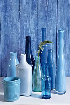 several different colored glass vases sitting on a table