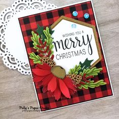 a christmas card with a red flower and green leaves on the front, sitting on top of a doily