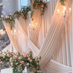 a room with flowers and chandeliers hanging from the ceiling