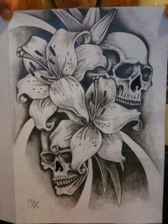 a person holding up a drawing with flowers and skulls on it in front of their face