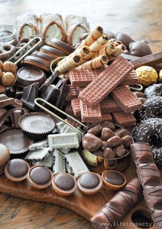 an assortment of chocolates and candies on a wooden tray