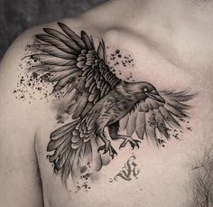 a man's chest with a bird tattoo on it