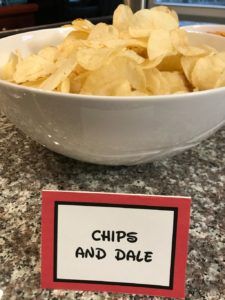 chips and dale sign sitting on top of a counter next to a bowl of chips