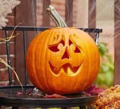 a carved pumpkin sitting on top of a chair