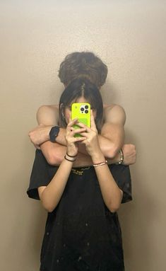 two people taking a selfie in front of a mirror with their arms around each other