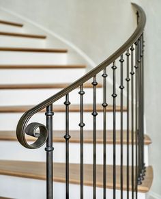 an iron stair railing with wood handrails