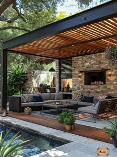 an outdoor living area with couches and tables next to a pool surrounded by trees