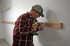 a man working on a piece of wood with a screwdriver in his hand