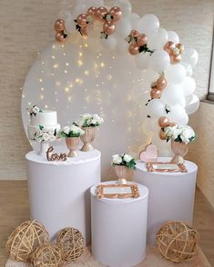 three white round tables with gold and white decorations on the top one is decorated with balloons