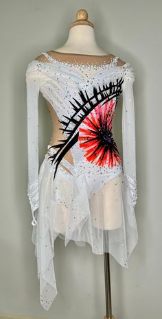 a white dress with red and black designs on it