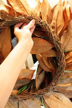 someone is making a wreath out of leaves