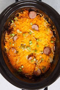 a crock pot filled with sausage, cheese and hashbrowns in it