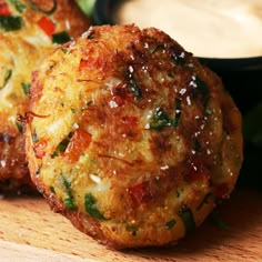 two crab cakes on a cutting board with dipping sauce