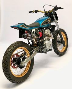 a blue dirt bike parked on top of a white floor