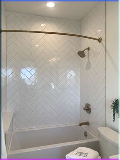 a bathroom with a toilet, bathtub and shower head mounted to the side of the wall