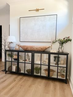 a living room filled with furniture and a large painting on the wall above it's glass doors