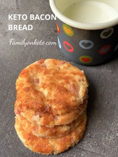 a stack of biscuits next to a cup of milk on a table with the words keto bacon bread