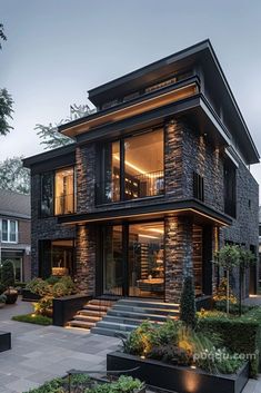 a modern house with stone walls and steps leading up to the second floor, surrounded by greenery