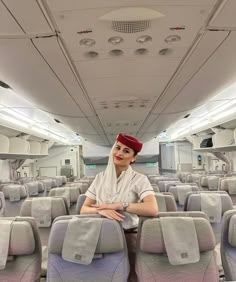 a woman is sitting on an airplane with her arms crossed and looking at the camera