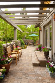 an outdoor patio with chairs and potted plants