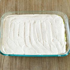 a casserole dish with white sauce in it on a wooden table, ready to be eaten