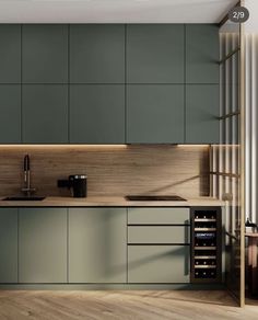 a modern kitchen with green cabinets and wood flooring on the walls, along with a wine rack