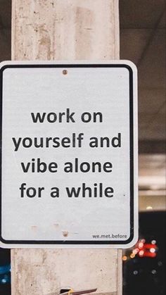 a sign on a pole that says work on yourself and vibe alone for a while