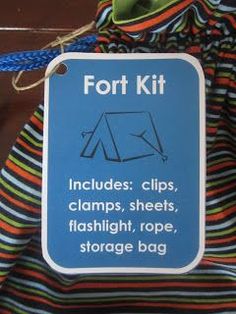 a sign on the back of a backpack that says fort kit includes clips, clamps, sheets, flashlight, rope, and storage bag