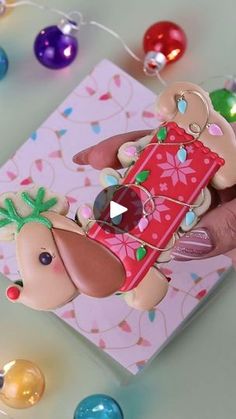 a close up of a person's hand holding an ornament with a dog on it