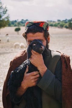 a man holding a small dog in his hands