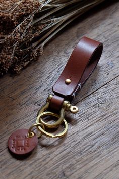 a brown leather keychain with a gold ring