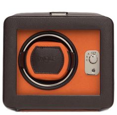 an orange and brown box with a black ring in it's center on a white surface