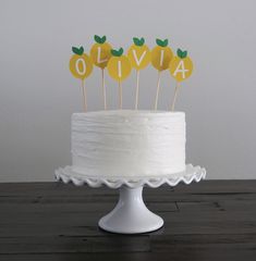 a white cake topped with lemons on top of a wooden table