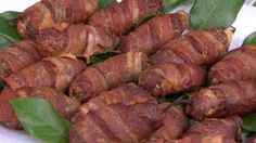 bacon wrapped in green leaves on a plate