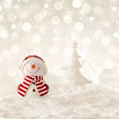 a snowman with a red and white scarf on it's head standing in the snow