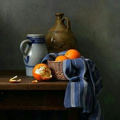 an orange sitting on top of a wooden table next to a vase and other items