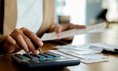 a person sitting at a desk with a calculator