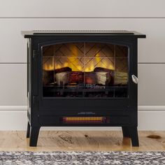 a wood burning stove in a room with pictures on the wall above it and below it